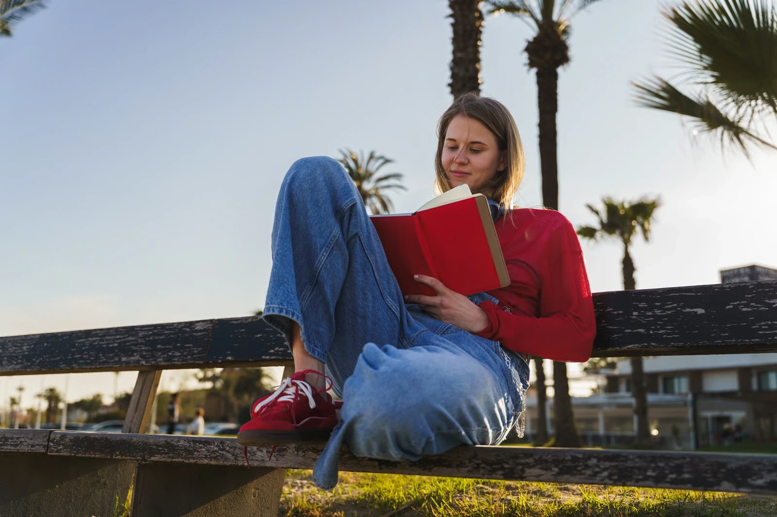 Woman reading a book on a park bench
