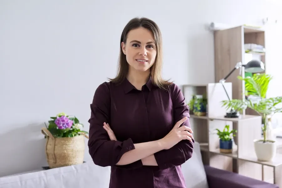 Woman smiling with folded arms in a bright living room