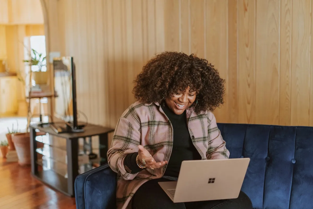 Woman smiling on a video call from her couch at home